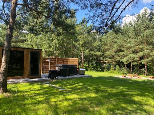 a cabin in a yard with green grass at Dom Na Brzegu Ciszy in Pasym