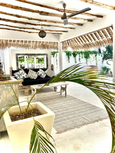 a living room with a couch and a plant at Beba.Beach.House in Watamu
