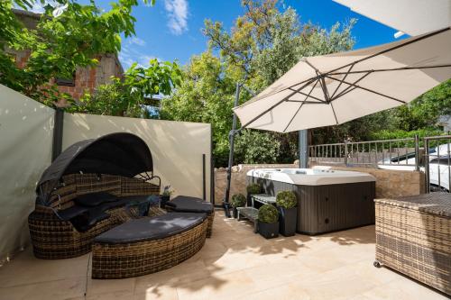 a patio with a chair and an umbrella at Sunset B Apartment with Private Jacuzzi in Novalja
