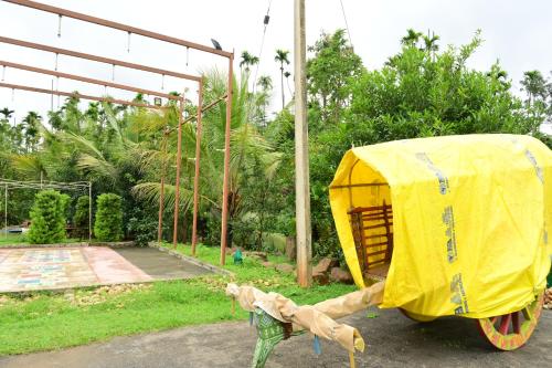 a wooden cart with a yellow cover on it at DELIGHTFUL HOMESTAY in Sollebail