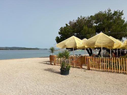 a group of yellow umbrellas on a beach at Danyja Mobilehome in Biograd na Moru