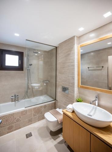 a bathroom with a tub and a sink and a toilet at G&S House in Tsoukalades