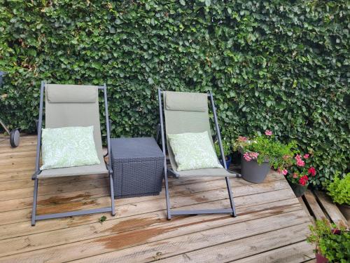 two chairs sitting on a patio next to a hedge at Sweet home 9G in Sprimont