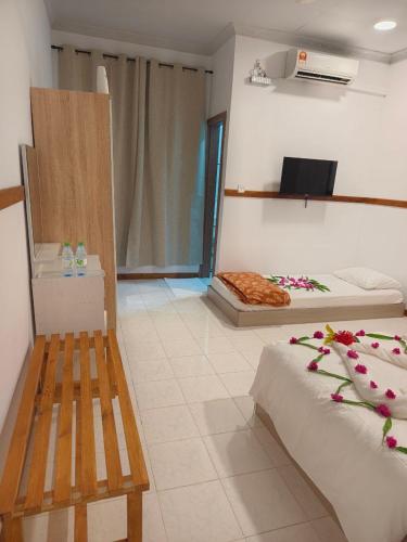 a room with two beds with flowers on them at Mirusmaa Inn 