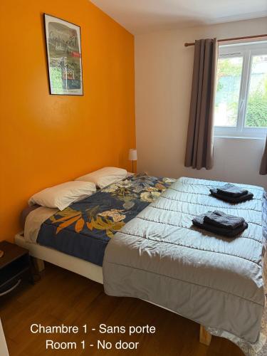 une chambre avec un lit dans une pièce aux murs orange dans l'établissement Gîte de Preuilly, à Auxerre