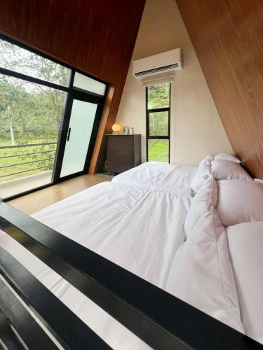 a bedroom with a white bed with a large window at Madria Loft Cabin in Baras