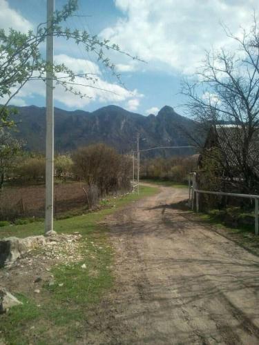 a dirt road with a pole and mountains in the background at Hovk Guesthouse in Hovkʼ
