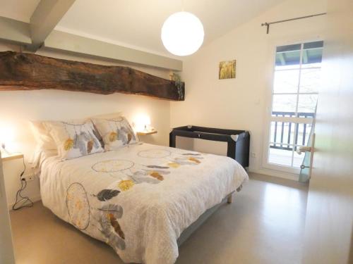 a bedroom with a large bed and a window at L'etable in Orx