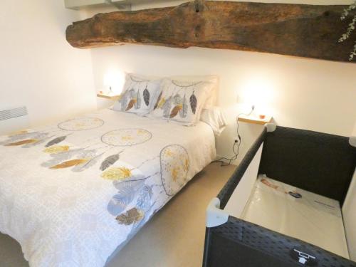 a bedroom with a bed and a computer monitor at L'etable in Orx