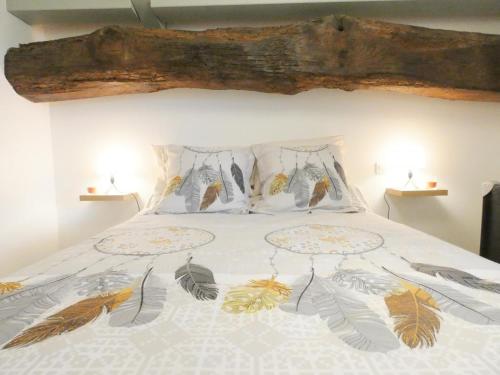 a bedroom with a bed with feathers on it at L'etable in Orx