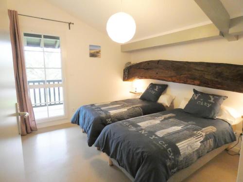 a bedroom with two beds and a large window at L'etable in Orx