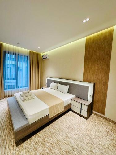a bedroom with a large bed and a large window at North Star Hotel in Yakkasaray