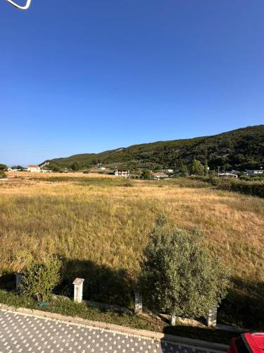 a field of grass with a hill in the background at Lalzi bay Home in Fushë-Draç