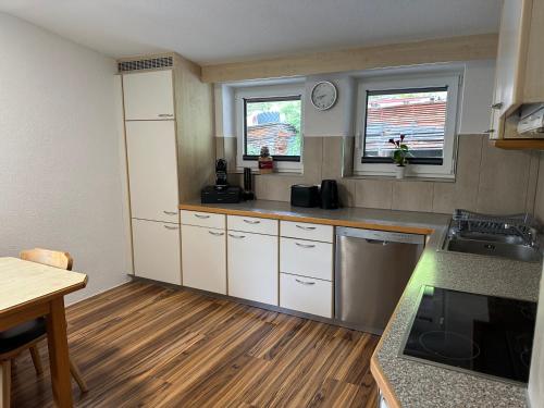 a kitchen with white cabinets and a wooden floor at Apart Neunerhof in Jerzens
