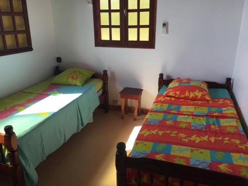 a bedroom with two beds and a table in it at Maison dans la corniche or in Pointe-Noire