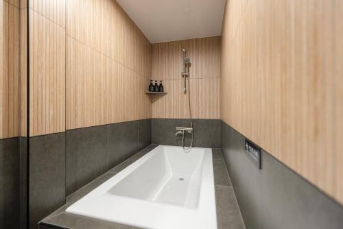 a bath tub in a bathroom with a shower at Yuhyu Ryokan Hotel in Seoul