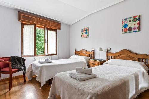 a bedroom with two beds and a red chair at Romano I megustarural in Porrúa