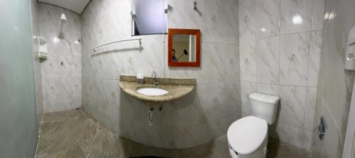 a bathroom with a sink and a toilet at JV Pousada in Paraty