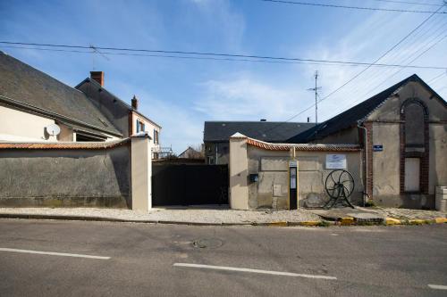 an old building with a gate in front of a street at La Grange - Maison et Parking - Portes de Chartres in Jouy