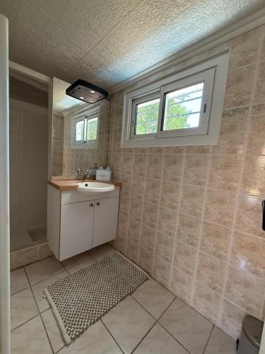 a bathroom with a sink and a window at La Maison de la forêt et son jaccuzy in Biscarrosse