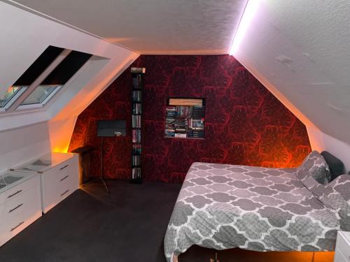 a bedroom with a bed and a red wall at B & B Huize Hertog met Whirlpool in Apeldoorn