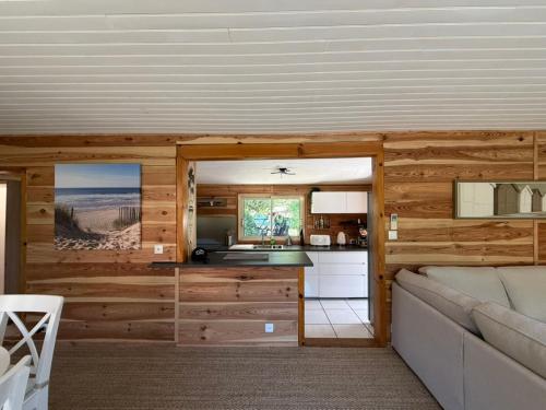 a living room with a couch and a kitchen at La Maison de la forêt in Biscarrosse