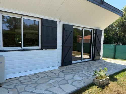 a screened in porch of a house with windows at La Maison de la forêt in Biscarrosse