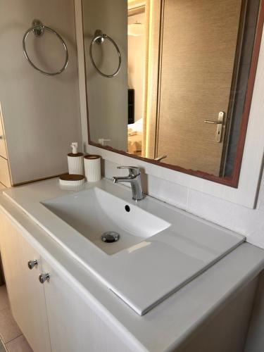 a bathroom with a white sink and a mirror at Latomi Sea View in Chios