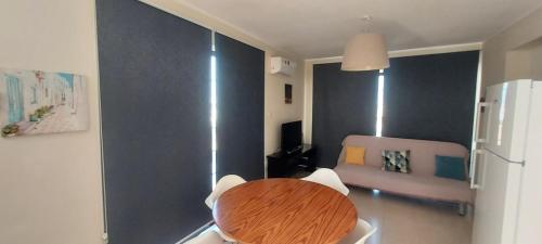 a dining room with a table and a refrigerator at Magic Sea Apartments in Larnaka