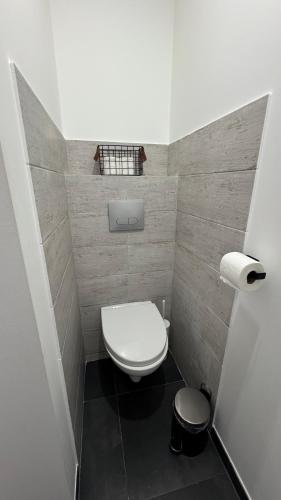 a small bathroom with a white toilet and a black floor at Escapade à 2 pas de la Loire in Sandillon
