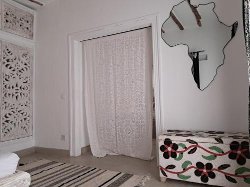 a white room with a door with a curtain at Beba.Beach.House in Watamu