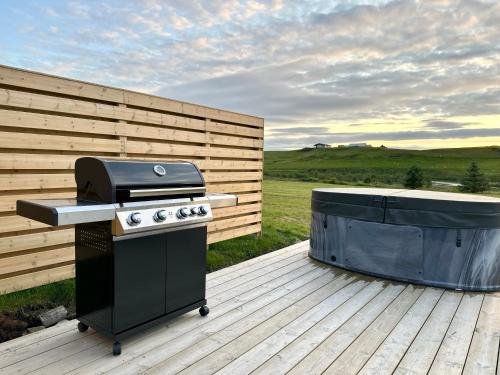 a grill and a tub sitting on a deck at Nest Retreat Iceland in Hella