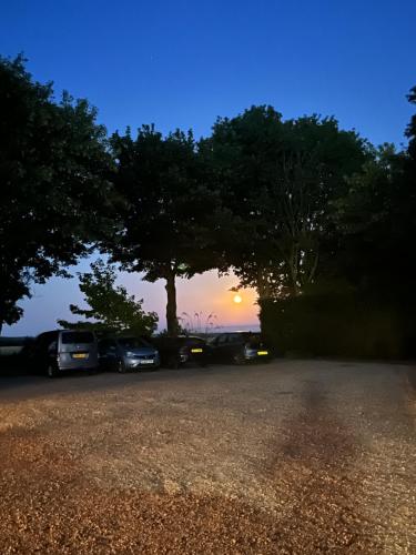 a group of cars parked in a parking lot at sunset at Cottage Lea's Country Hotel & Restaurant in Pickering