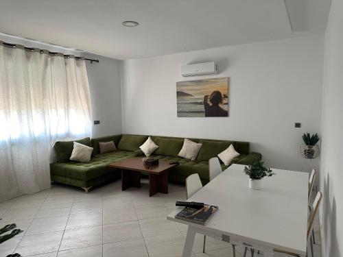 a living room with a green couch and a table at Appartement Bleu Azur, Saïdia Plage in Saidia 