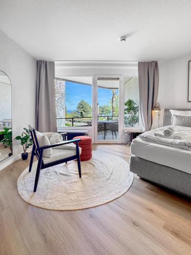 a bedroom with a bed and a chair at Design-Apartment mit Meerblick in Travemünde