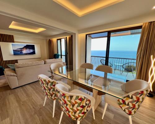 un soggiorno con tavolo e sedie in vetro di Ocean Horizon a Funchal