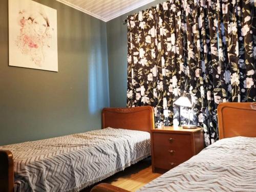 a bedroom with two beds and a curtain with flowers at Larnaca Breeze in Pyla