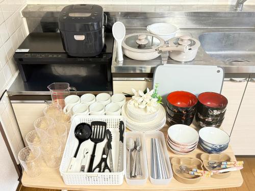 a drawer filled with dishes and utensils in a kitchen at Camelot Home in Fukuoka