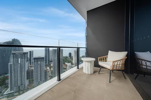 a balcony with a chair and a view of the city at Starview Suite - Private Oceanview 2 Bedroom Apartment on the Star Residence Broadbeach, Free Carpark Included with your stay! in Gold Coast