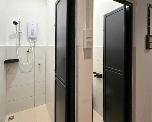 a bathroom with a black door and a shower at Toh Aka Inn in George Town
