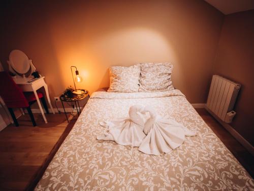 a white bed with a swan decoration on it at Casa Di Vibes - Jacuzzi - Sauna in Saint-Maur-des-Fossés