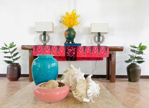 a table with two vases and two lamps on it at Casa G Private BeachfrontYour own private beach in Samal