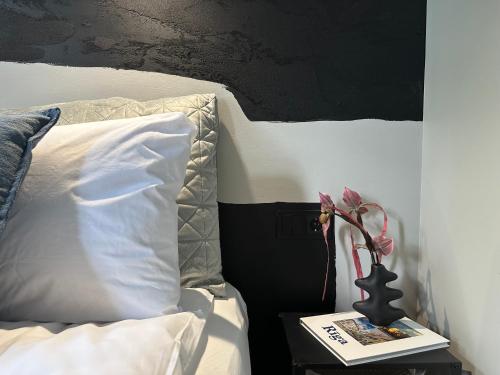 a bedroom with a bed and a table with a vase on it at RixStay Apartments in Rīga