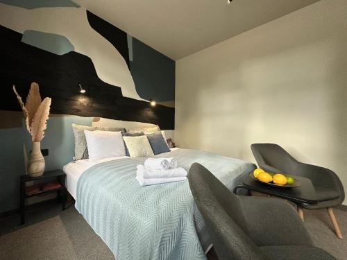 a bedroom with a bed with two chairs and a table at RixStay Apartments in Rīga