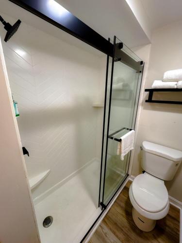a bathroom with a toilet and a glass shower at The Earl of Sandwich Motel in East Sandwich