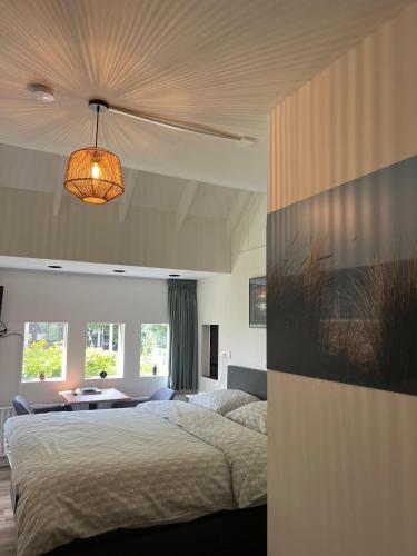 a bedroom with a large bed and a table at B&B De Dreef in Middelburg