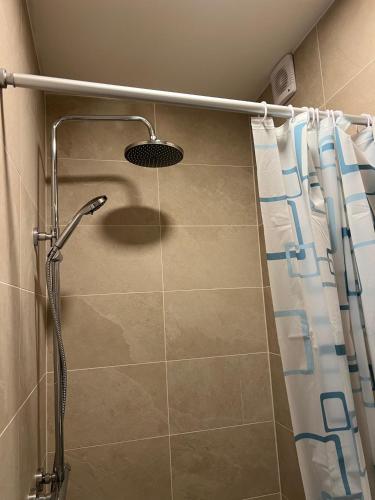 a shower with a shower curtain in a bathroom at B&B De Dreef in Middelburg