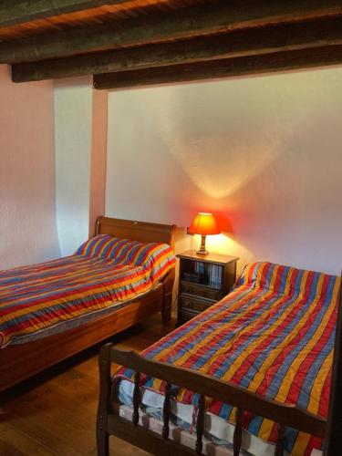 a bedroom with two beds and a lamp on a table at Le refuge cerdan in Saint-Pierre-dels-Forcats