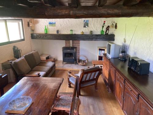 a living room with a couch a table and a fireplace at Le refuge cerdan in Saint-Pierre-dels-Forcats
