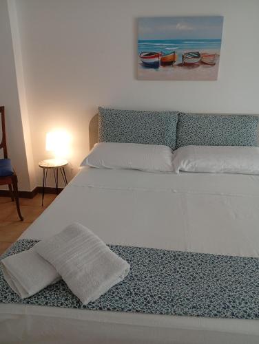 a large white bed with a towel on it at Casa AZZURRA in Giovinazzo